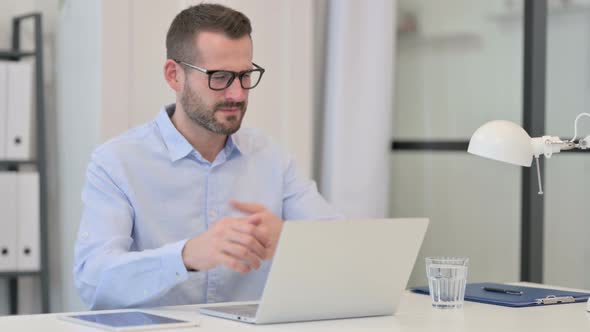 Middle Aged Man Feeling Angry While Working on Laptop