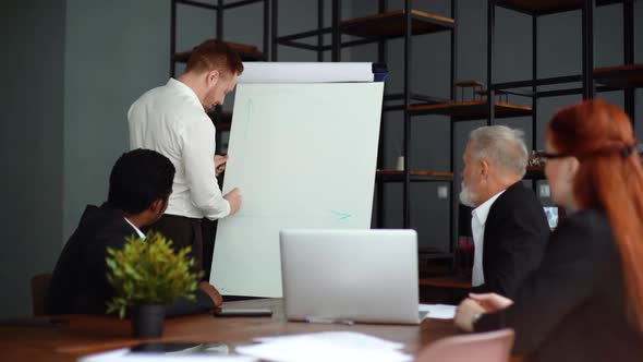 Handsome Man Coach Giving Lecture Presentation in Modern Office for Multiethnic Business Team