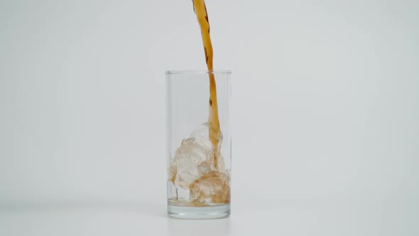 Slow Motion of Pouring Cola in Glass with Ice White Background