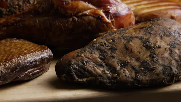 Rotating Shot of A Variety of Delicious, Premium Smoked Meats on A Wooden Cutting Board