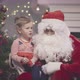 Santa Claus Talking to Cute Toddler Girl in Decorated Living Room - VideoHive Item for Sale