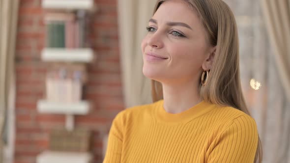 Portrait of Attractive Young Woman Thinking and Smiling