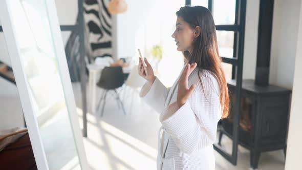 Young Woman Near a Mirror in Bathrobe