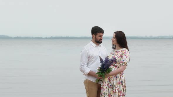 Young pregnant girl with her boyfriend on the Beach