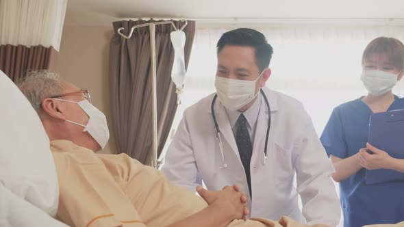 Asian doctor measure heart rate by stethoscope on old man patient on bed in recovery room.