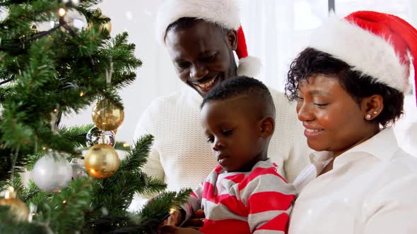 Happy Family Decorating Christmas Tree at Home