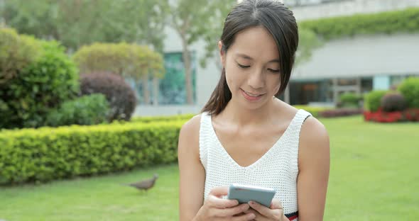 Woman using smart phone at park