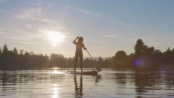 Adventurous Caucasian Adult Woman Paddling on a Stand Up Paddle Board
