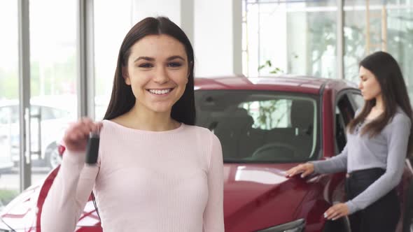 Cheerful Young Woman Showing Thumbs up Holding Car Keys