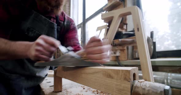 The Master Carpenter with a Planer at Work in the Workshop alt