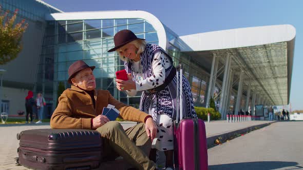 Senior Pensioner Tourists Grandmother Grandfather Buy Tickets Online on Mobile Phone Near Airport