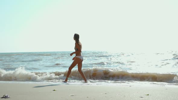 Happy Joyful Woman Jumping and Jogging Outdoors Along Sea Shore Feeling Wellness and Freedom