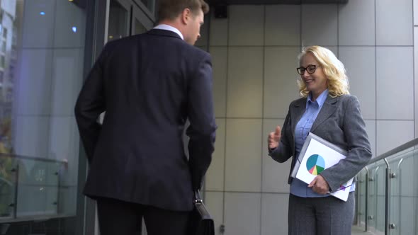 Smiling Aged Business Woman Meeting Young Male Employee, Partners Shaking Hands