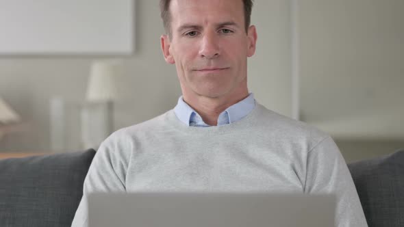 Portrait of Middle Aged Businessman Working on Laptop at Home
