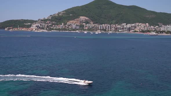 Motor Boat Sails Along the Bay Past the Coast of Budva