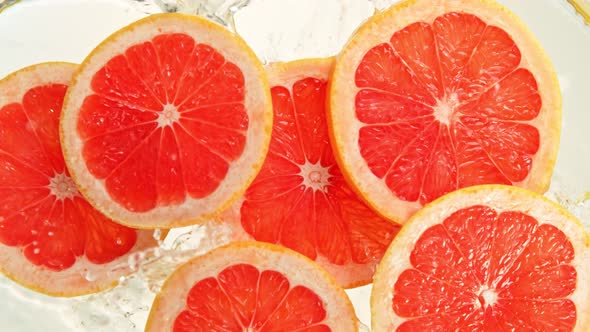 Super Slow Motion Shot of Grapefruit Slices Falling Into Water at 1000Fps.