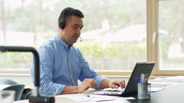 Man with Headset and Laptop Working at Home