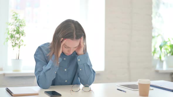 Young Woman having Headache in Modern Office