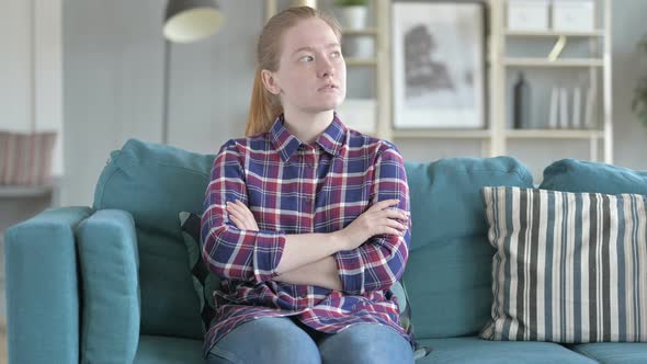 Young Woman Sitting on Couch And Thinking