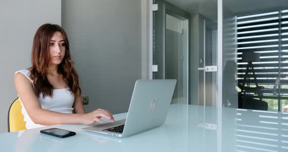 Young Business Woman Typing on Laptop