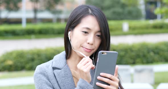 Woman talking on mobile phone with earphone at outdoor