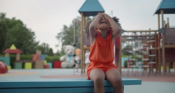 Lonely Upset Afroamerican Little Girl Crying Sitting on Bench Outdoors