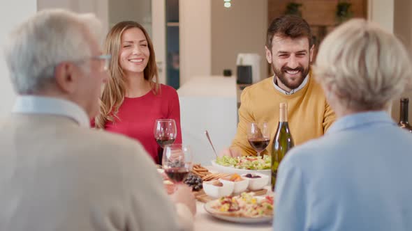 Happy family having a dinner with red wine at home