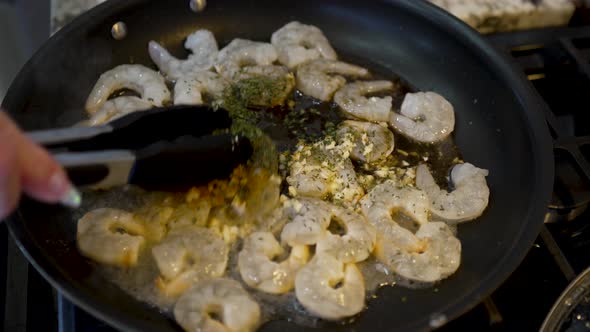 Mixing the spices in to a frying pan full of shrimp - shrimp and grits meal