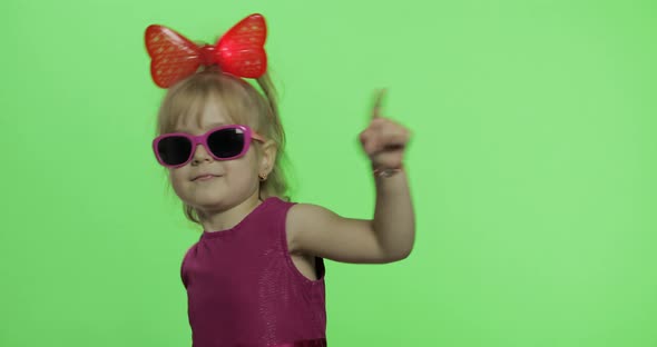 Girl Dancing in Purple Dress, Sunglasses and Red Ribbon on Head. Chroma Key