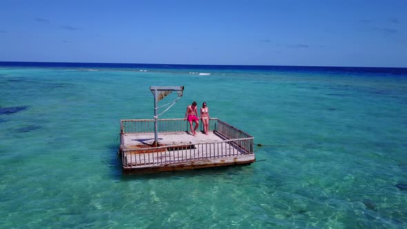 Beautiful man and woman on honeymoon vacation live the dream on beach on clean white sand 4K background