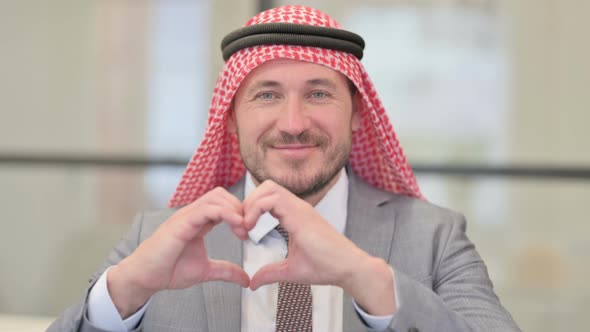 Portrait of Middle Aged Arab Businessman showing Heart Shape by Hands