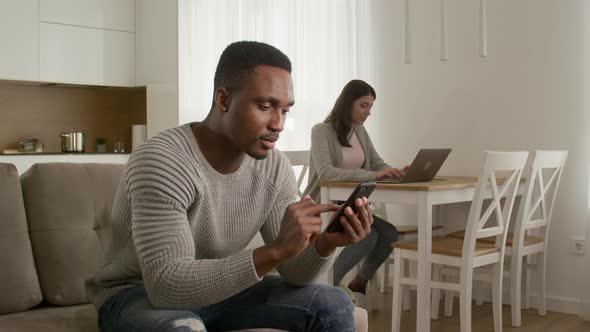 Young Adult Couple Couple Browsing the Web and Interact with Each Other While Sitting at Home
