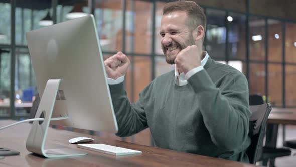 Success Man Celebrating While Working on Computer