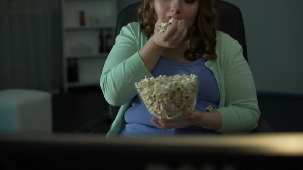 Girl Enjoying Silly Program on TV at Home, Eating and Scattering Popcorn Around