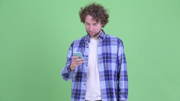 Happy Young Bearded Hipster Man Using Phone