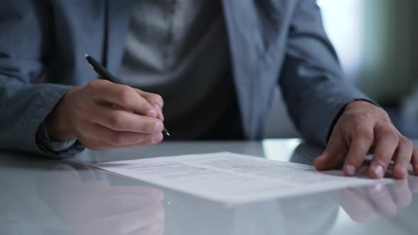 A Man Signs a Document