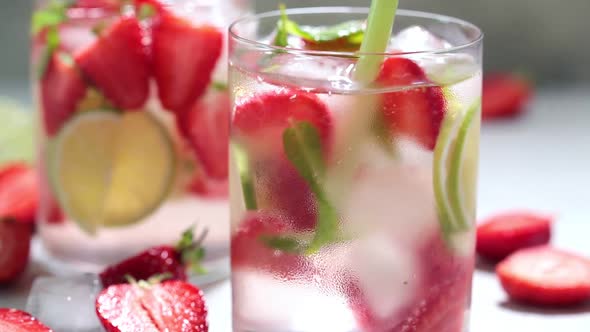 Detox sassy water with strawberries and lime in glasses. 