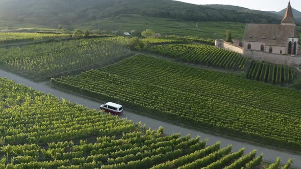Aerial view of a campervan driving near the little village.