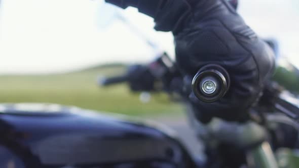 Close-up of the motorcyclist's hand twisting throttle handle of bike