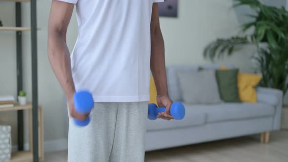 Close Up of African Man Working Out with Dumbbells at Home