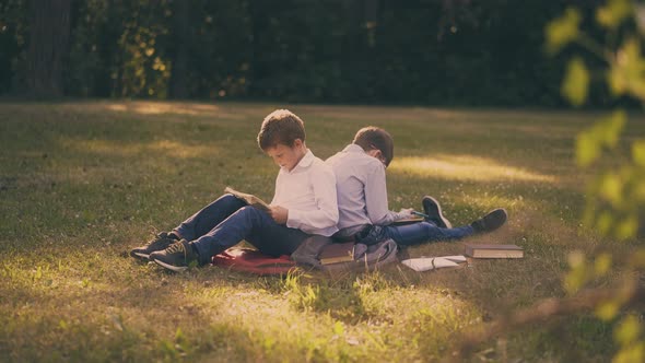 Schoolboys Read Books Doing Home Task on Lush Grass in Park