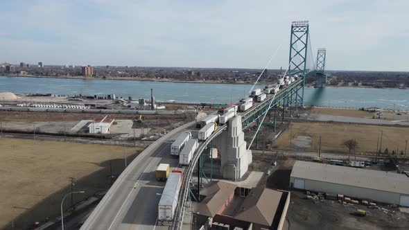 Endless line of trucks driving over Ambassador bridge to pass USA - Canada border. Aerial view, Detr