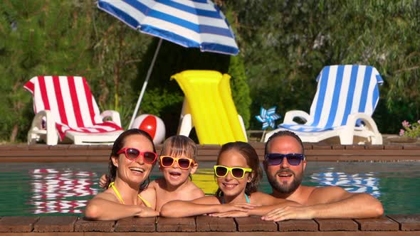 Happy family having fun in swimming pool