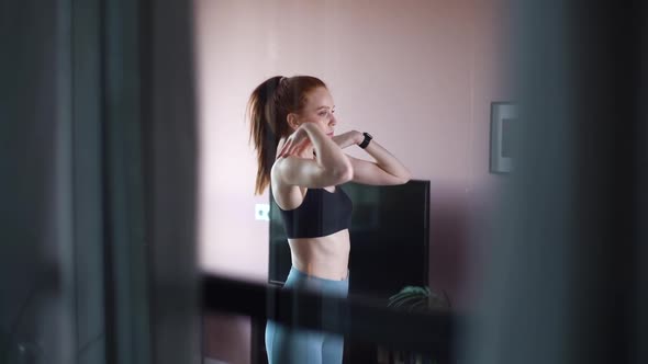 Remote View of Fitness Young Woman Doing Stretching Exercise for Arms and Shoulder Muscles at Home