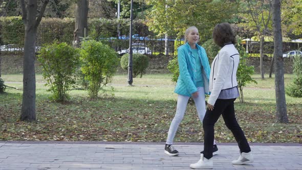 Side View of Young-looking Caucasian Grandmother and Her Teenage Granddaughter Dressed in Casual