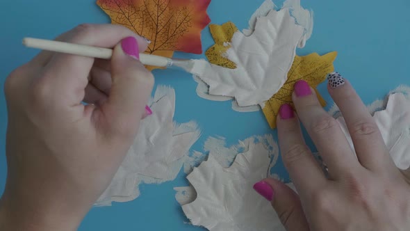 Female Hand Paint on Maple Leaf Face As Decoration for Autumn Halloween Holiday Celebration