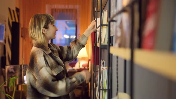 Portrait of Clever Student with Open Book Reading It in College Library