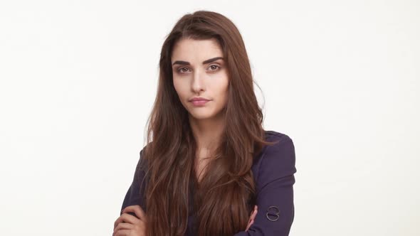 Skeptical Young Caucasian Female with Brown Hair Wearing Dark Blue Shirt Looking Forward on White