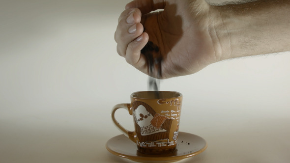 Pouring Coffee Beans Into Small Coffee Cup