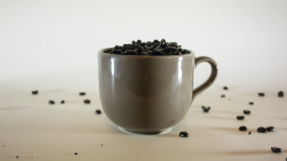 Pouring Coffe Beans In Big Coffee Mug